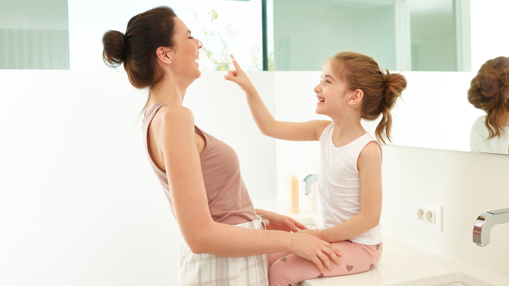 Mãe e filha a brincar na casa de banho