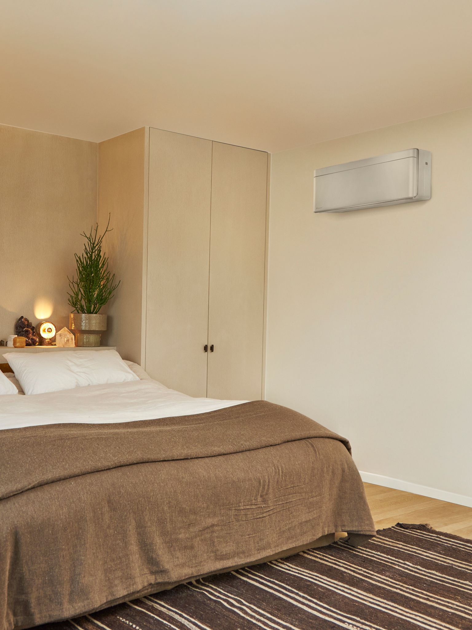 Quarto com uma cama grande e uma solução de climatização mural